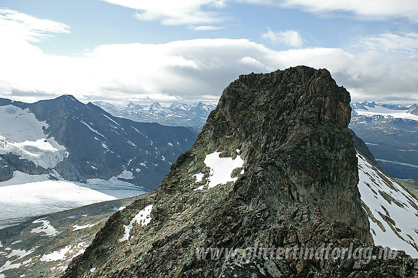 Midtre Skarvflytinden (2154 moh) sett fra sør. Å gå bratta rett opp krever normalt sikring. Langt enklere er det å gå omveien ned i flanken til venstre og runde opp fra baksiden.