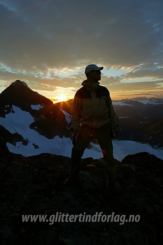 Sola går ned over Jotunheimen mens vi står på Midtre Leirungstinden og nyter det hele. Bak til venstre silhuetten til Store Knutsholstinden (2341 moh).