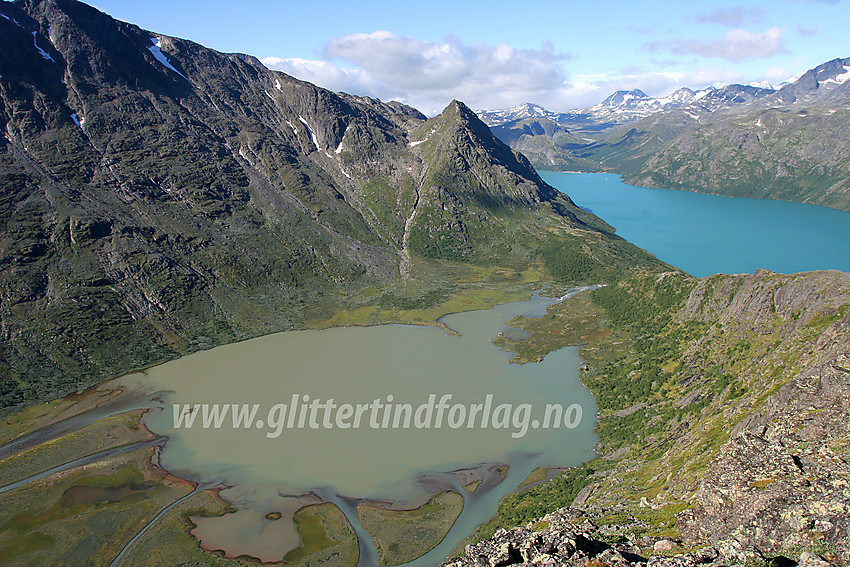 På vei over Knutshøe en flott sommerdag med Jotunheimens tindeteppe i bakgrunnen. Toppen er passert, og utsikten ned mot Øvre Leirungen og bort mot Veslløyftet og Veslløyfttinden storslått. 