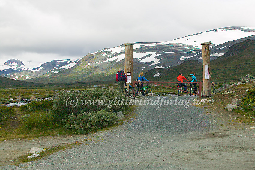 Syklister gjør seg klar for sykkelturen opp til Glitterheim. Bildet er tatt ved nasjonalparkgrensa i Veodalen, der det er stor parkeringsplass og stopp for videre bilkjøring.