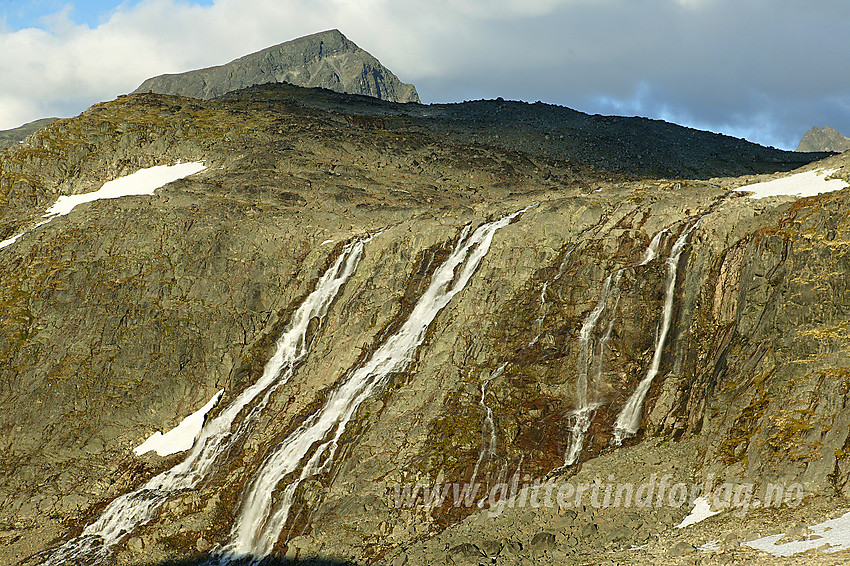 Flerdelt fossefall nedenfor Leir-/Smørstabbrean. I bakgrunnen ses Store Smørstabbtinden (2208 moh). Sokse (2189 moh) kan anes i høyre bildekant.