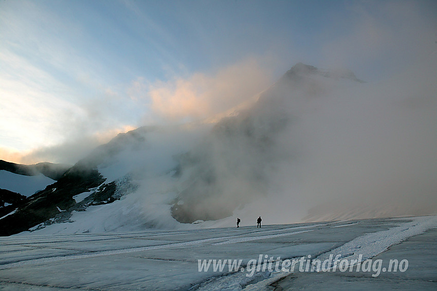 På Gjertvassbreen ved soloppgang med Gjertvasstinden (2351 moh) delvis gjemt av tåkeskyer i bakgrunnen.