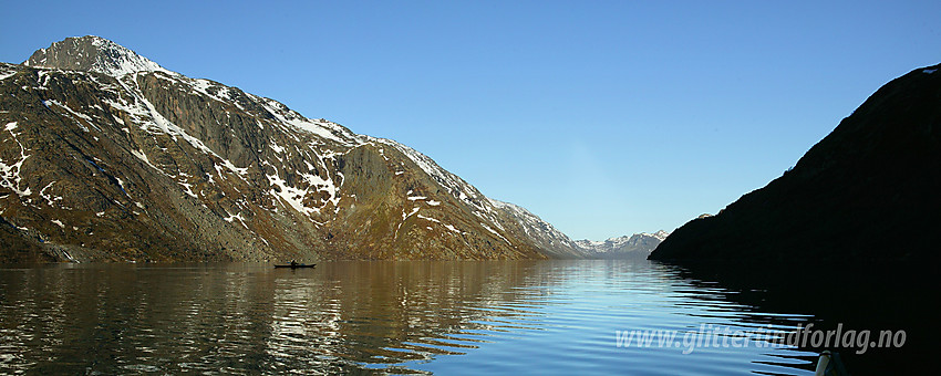 Padling på Gjende en flott sommermorgen. Bak padleren på bildet ses Memuruhåmåren som fører helt opp til Eggen (2041 moh).