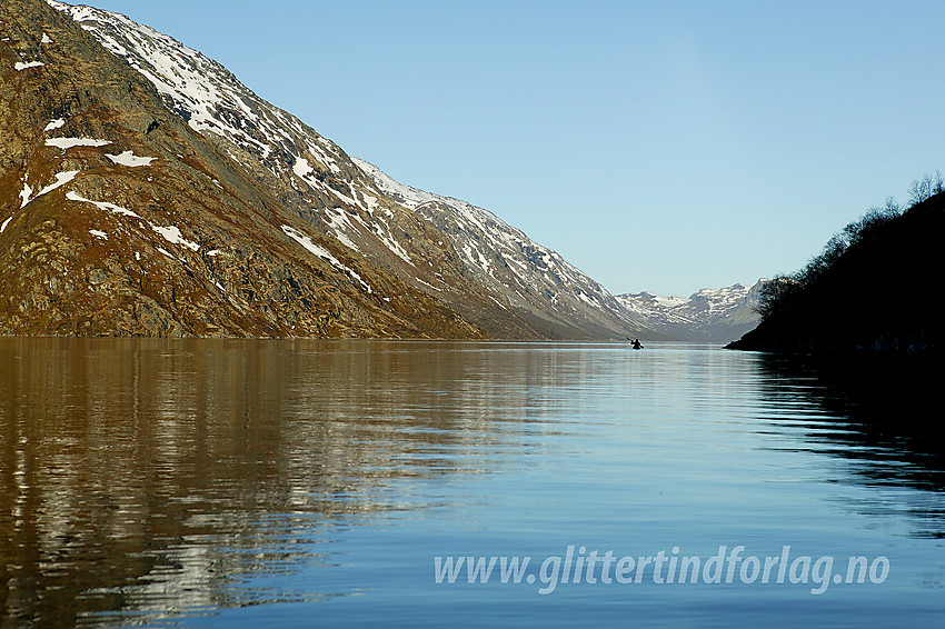 Padling på Gjende en nydelig sommermorgen. Bak til venstre ses Memuruhåmåren. Helt innerst i det fjerne begynner Veslådalen der Gjende tar slutt.