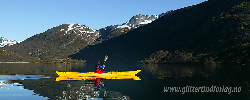 Padling på Gjende, like øst for Memuruhåmåren, med Memurubu i bakgrunnen.