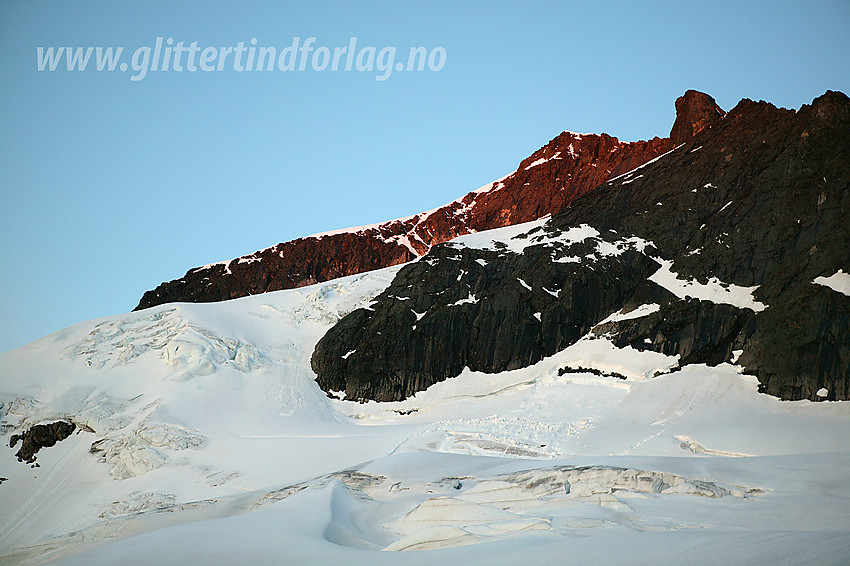 Store Knutsholstinden (2341 moh) sett fra nord. I forgrunnen den bratte breen som klorer seg fast i østflanken. Vi gikk opp breen til høyre for en del issvuller, i den bratte snøbakken der det har gått et ras og så litt ut til venstre. Opp til østryggen på Knutsholstinden kom vi via bratte snøformasjoner som kan ses på bildet oppe i solveggen.