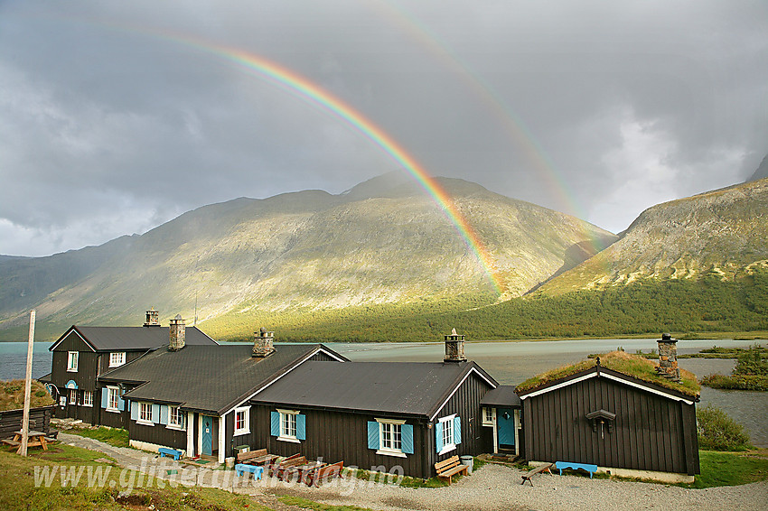 Gjendebu med en dobbeltregnbue i bakgrunnen.