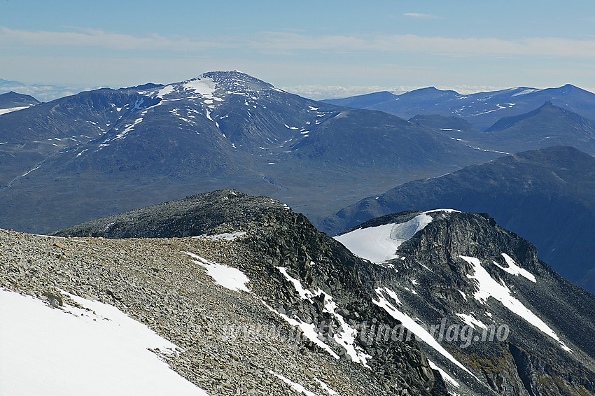 Keilhaus topp (2355 moh.) og Svellnose (2272 moh.) sett fra innunder toppen av Galdhøpiggen. I bakgrunnen reiser Glittertinden (2464 moh.) seg høyt over Skautflye, med Glitter-Rundhøe og Ryggjehøe mot høyre. Helt i bakgrunnen til høyre skimtes Nautgardstindmassivet.