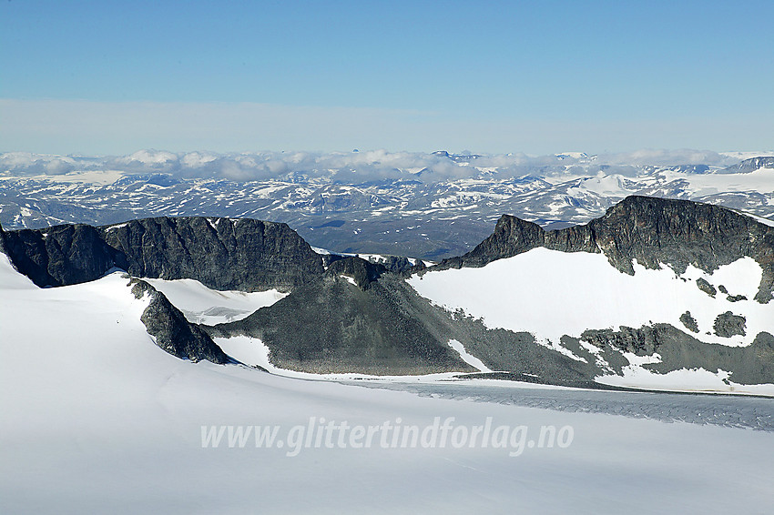 Utsikt fra Galdhøpiggen (2469 moh.) over Storjuvbrean mot (fra høyre mot venstre) Bakarste (2259 moh.) Storgrovhøe, Storgrovtinden (2229 moh.), Nørdre Heimre Illåbreatinden (2170 moh.) og Søre Heimre Illåbreatinden (2175 moh.). Bakenfor til venstre ses Dumhøe (2181 moh.).