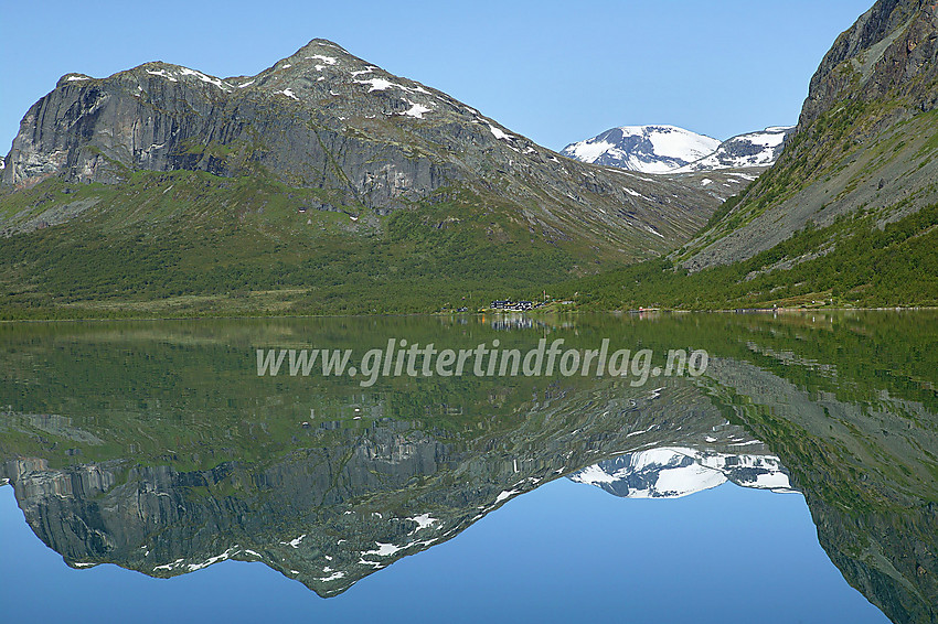 Padling på Gjende. Etter noen timer i kajakken nærmer vestenden seg omsider. Til høyre seg Gjendebu med Gjendetunga (1516 moh) bakenfor. Bak til høyre, med snø på, ses Snøholstinden (2141 moh).