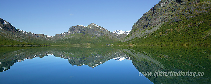 Padling på Gjende. Etter noen timer i kajakken nærmer vestenden seg omsider. Til høyre seg Gjendebu med Gjendetunga (1516 moh) bakenfor. Bak til høyre, med snø på, ses Snøholstinden (2141 moh).