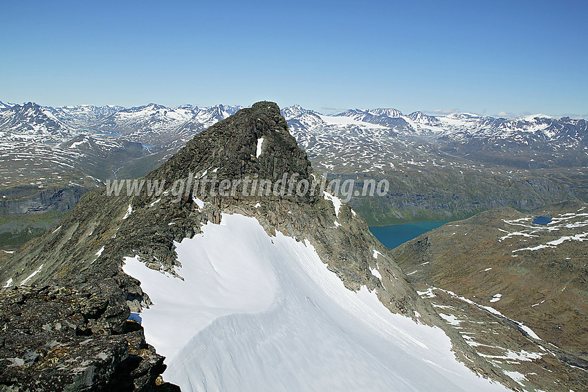 På ryggen sør for Nørdre Svartdalspiggen mot denne. I bakgrunnen bl.a. Gjende, Storådalen og tallrike tinder over 2000 meter. Nede til høyre ses en flik av Svartdalen.