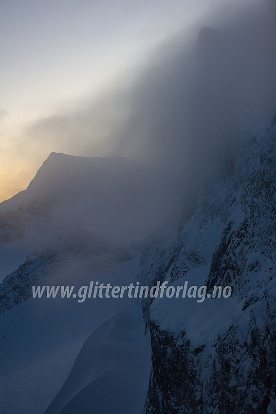 Stemningsfull morgen over Skardstinden (2373 moh) sett fra ryggen mellom Søre Dumhøe og Vestre Skardstinden. I bakgrunnen ses silhuetten til Galdhøpiggen (2469 moh).