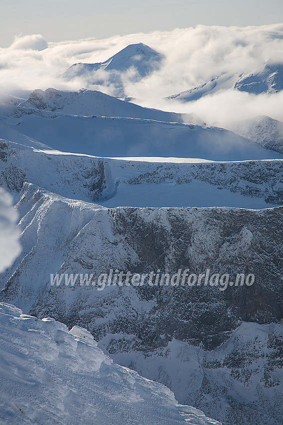 Fra Skardstinden i sør-sørvestlig retning med fjellrygg bak fjellrygg helt ut til Store Rauddalstinden (2157 moh) som er innhyllet i tåkeskyer.